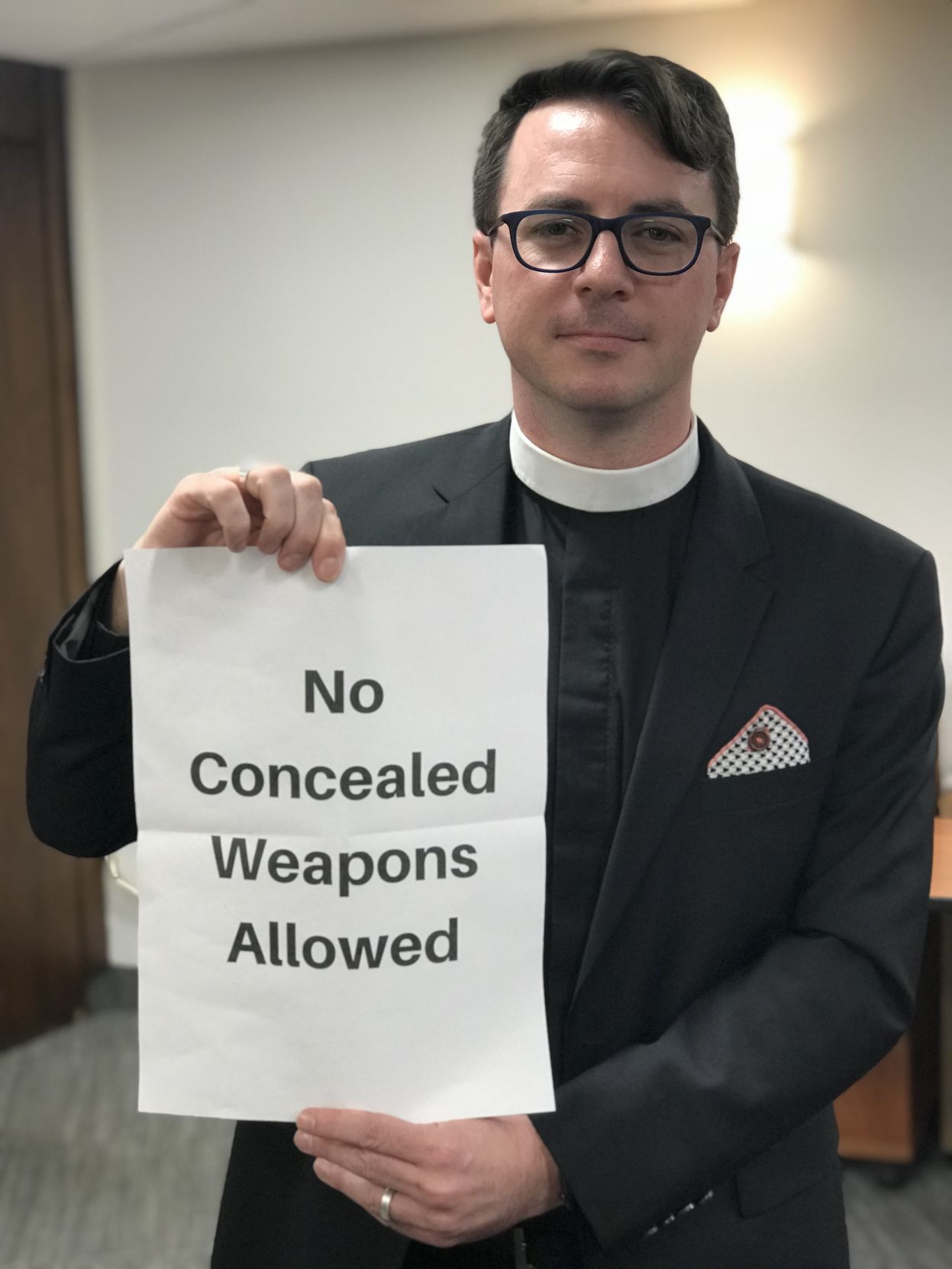 Rev. Angell poses with concealed carry sign